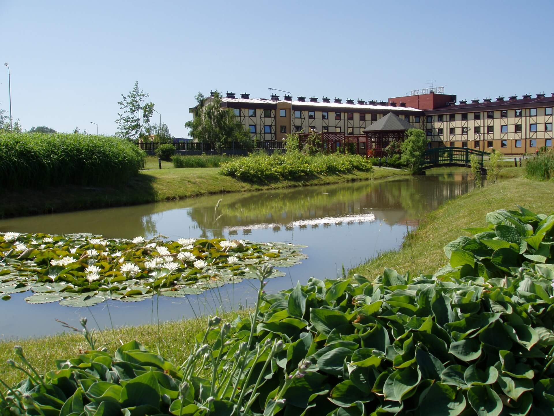Hotel 500 Tarnowo Podgórne z ogrodem, oczkiem wodnym i zielonym terenem wokół obiektu.